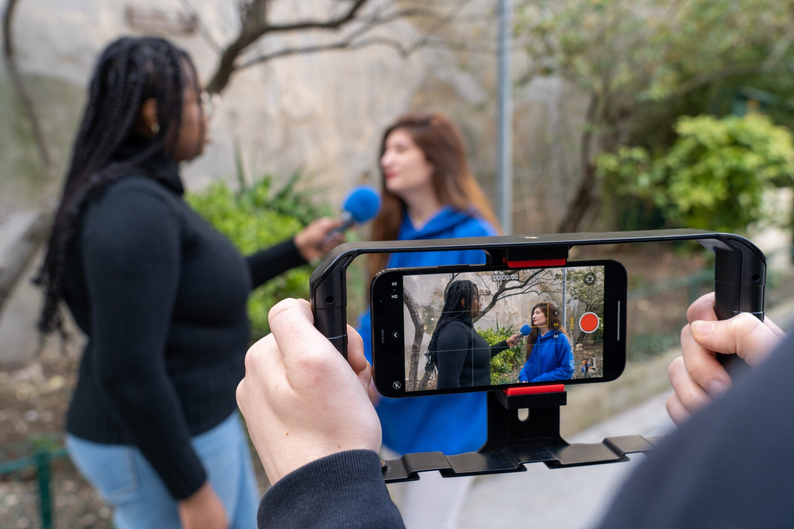 Étudiantes en journalisme filmant une interview